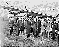 Photograph of President Truman and the Shah of Iran shaking hands at Washington National Airport upon the Shah's arrival in the United States, with the President's airplane,