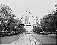 Photograph of a banner welcoming the Shah of Iran to Washington, during a parade in the Shah's honor, with a view of the Capitol in the background., 11/16/1949 - ARC Identifier: 200146.